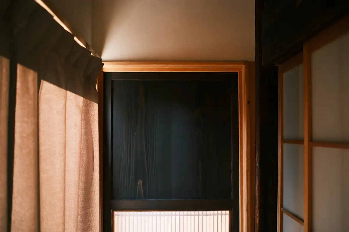 薄い布が下がる、暗い木の戸口